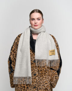 A grey cashmere scarf neatly folded in an elegant gift box.