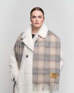 A folded light brown cashmere scarf in a luxury signature box.