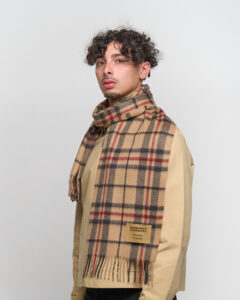 A male model wearing a beige cashmere scarf outdoors.